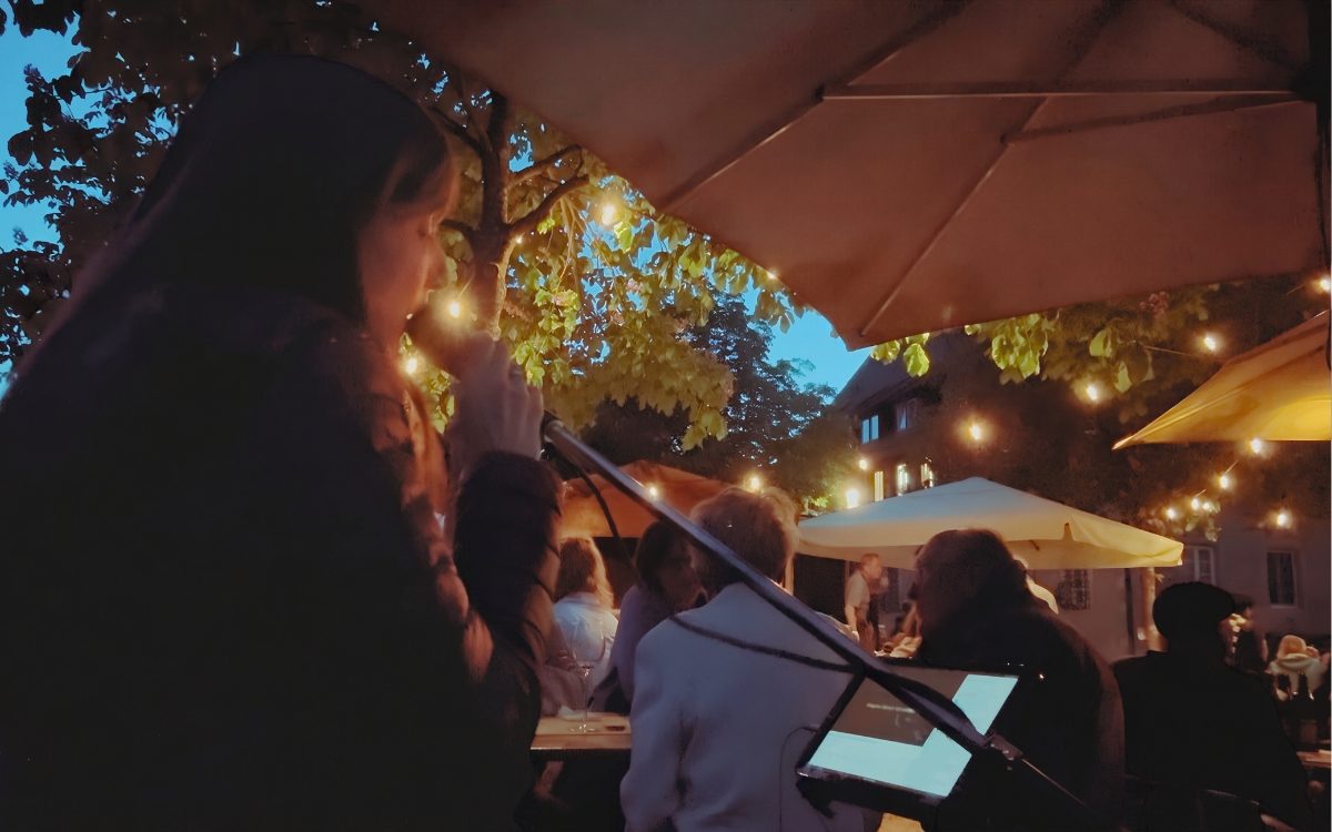 Luisa Loreen singt an einem Sommerabend in einem Biergarten unter Lichterketten.